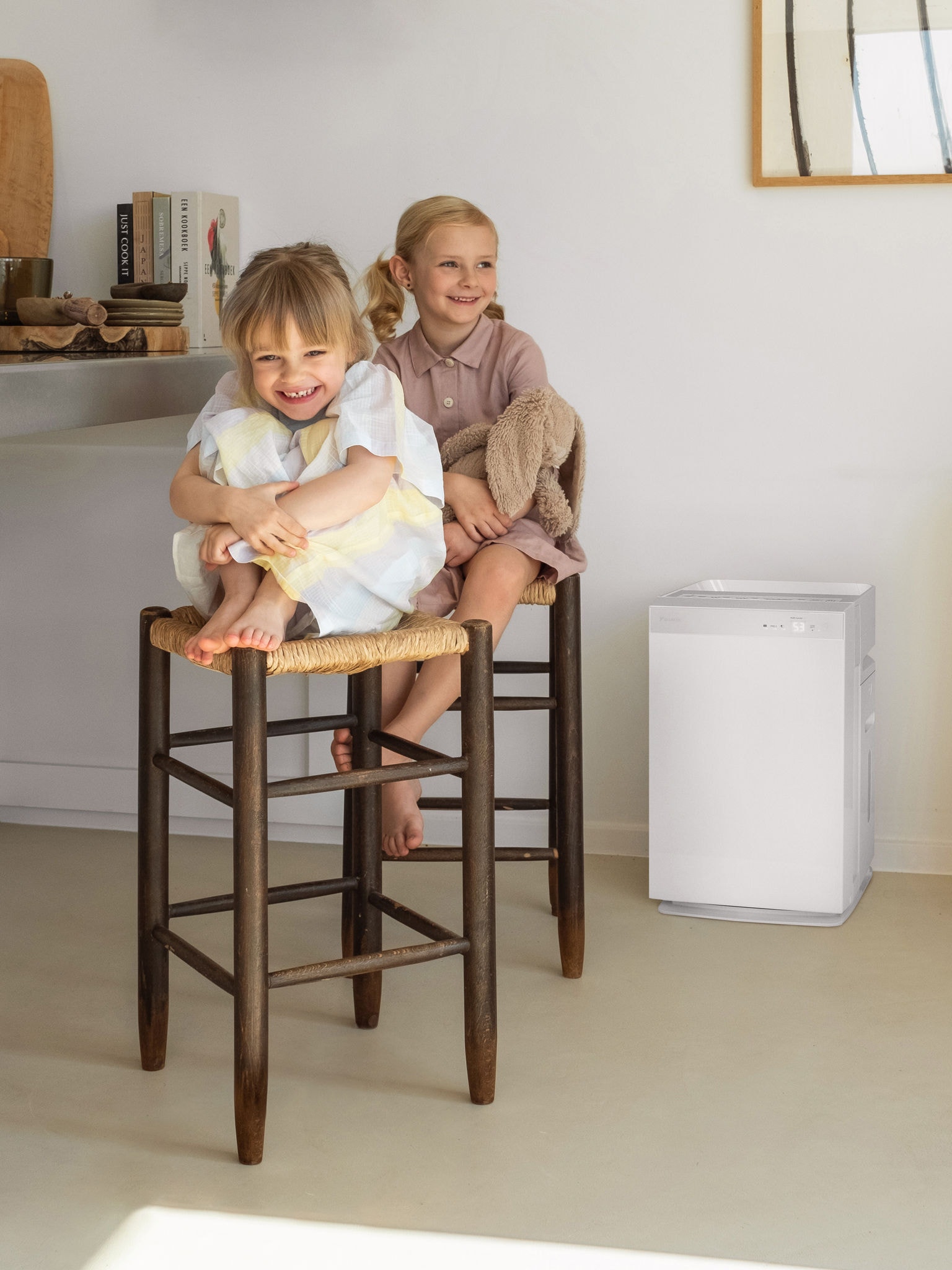 Due sorelline ridono sedute sugli sgabelli della cucina