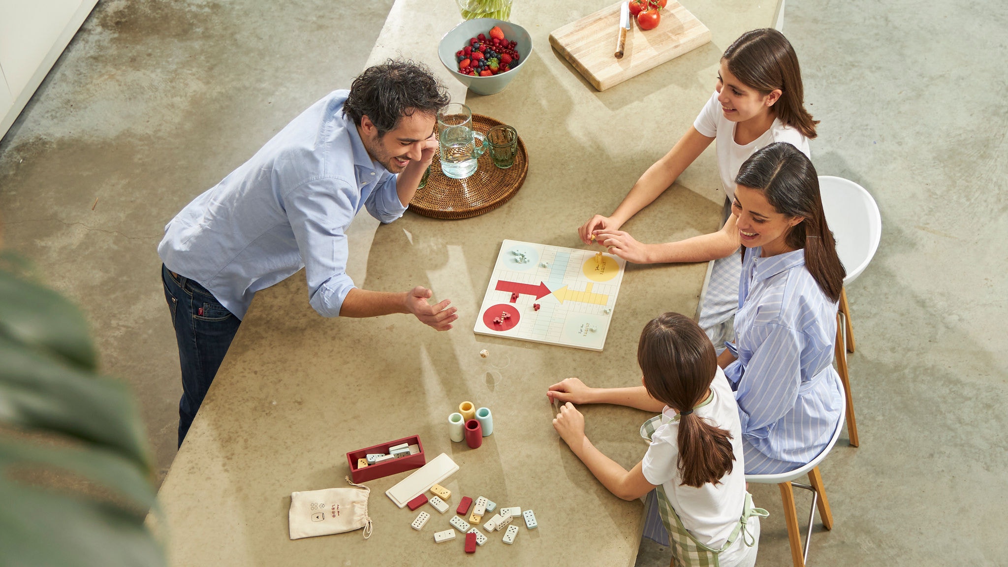 Una famiglia con due bambini gioca al tavolo della cucina in una casa a basso consumo energetico