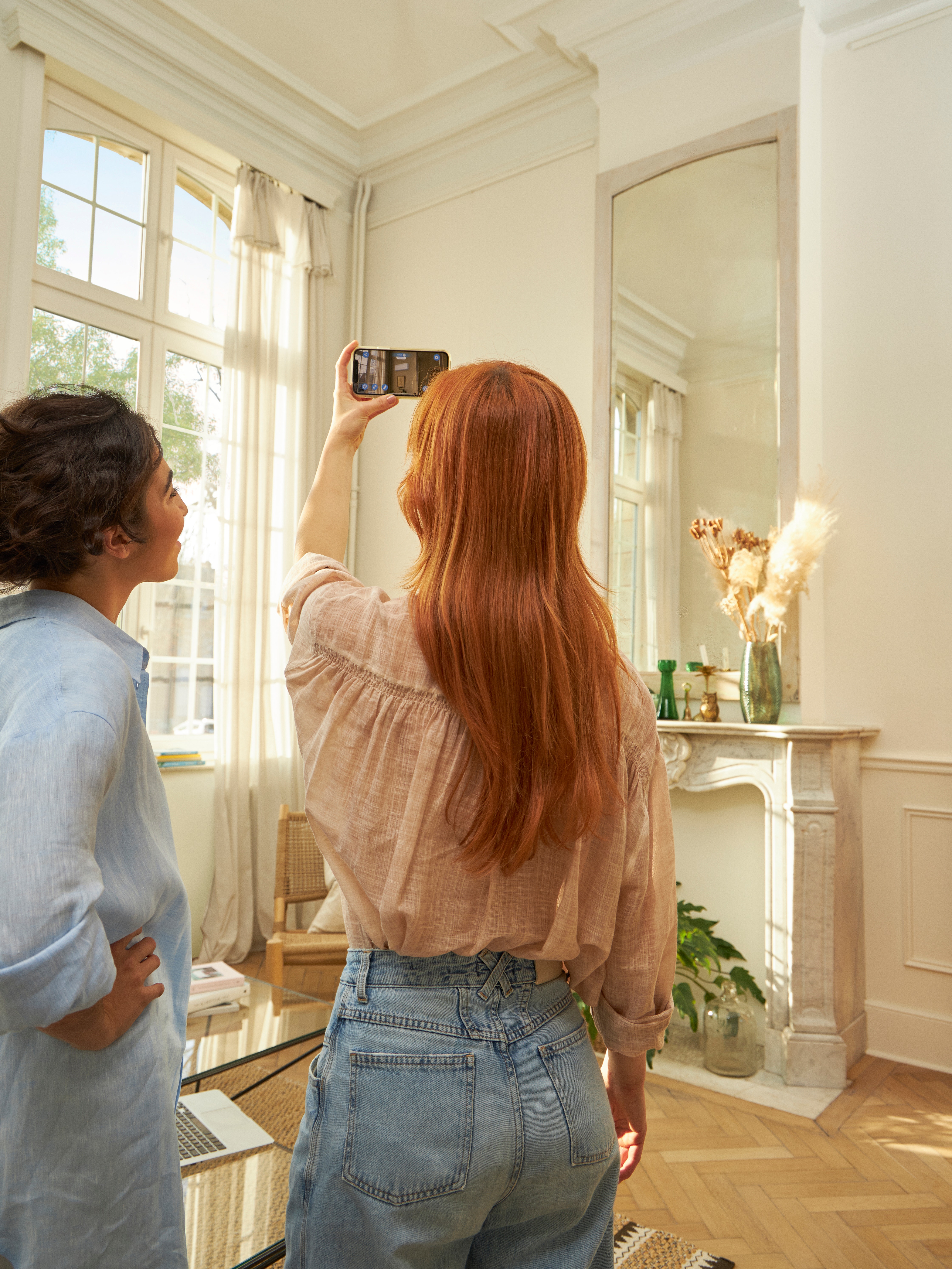 Una coppia mentre sta usando l'app 3D con realtà aumentata per visualizzare la pompa di calore aria-aria sia all'esterno che all'interno della sua casa