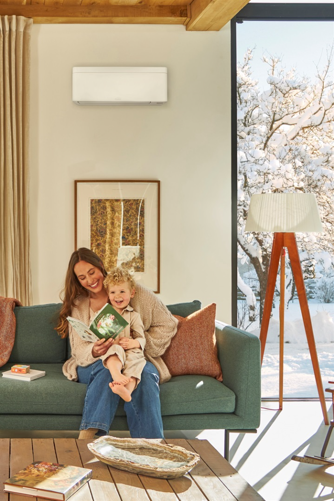 Mamma e figlio leggono un libro sul divano in un ambiente dalla temperatura confortevole