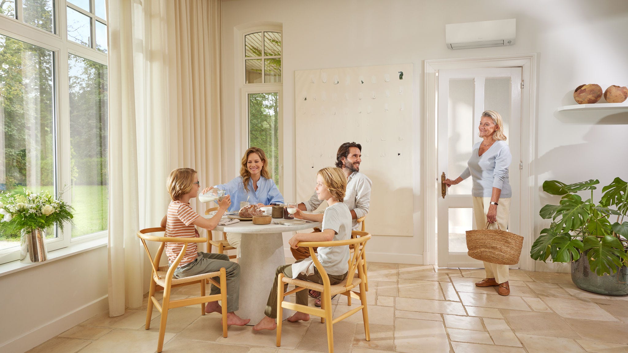 Una famiglia si rilassa in salotto al fresco, con il comfort offerto dalle soluzioni Daikin ad uso domestico