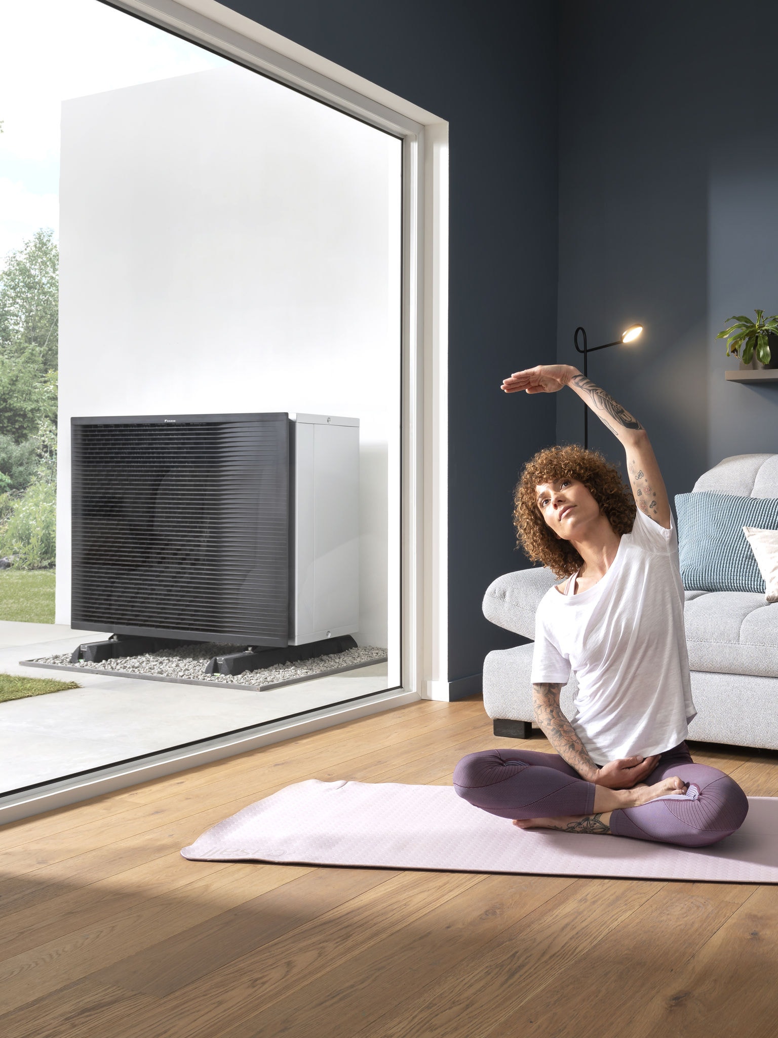 Una donna si dedica a una sessione di yoga nel suo salotto