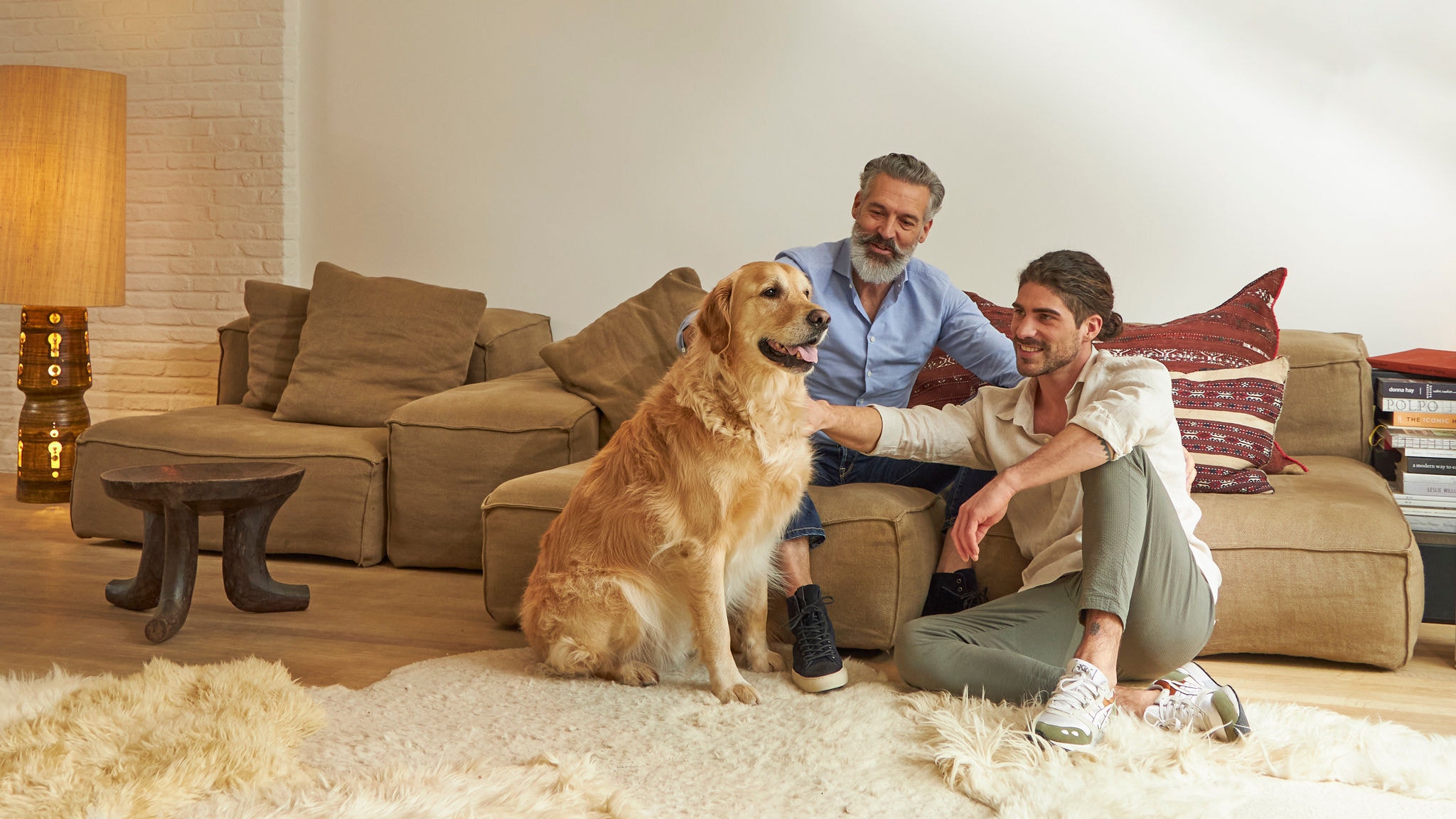 Due uomini accarezzano un cane nel loro accogliente soggiorno climatizzato